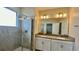 Stylish bathroom with a double sink vanity, framed mirror, decorative lighting, and a sleek glass-enclosed shower at 1258 Royal St George Blvd, Davenport, FL 33896