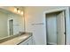 Bright bathroom showcasing a quartz vanity, a well-lit mirror, a towel rack, and a door to the separate toilet at 1258 Royal St George Blvd, Davenport, FL 33896