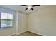 Carpeted bedroom with ceiling fan, a window letting in natural light, and neutral wall color at 1258 Royal St George Blvd, Davenport, FL 33896