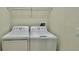 Efficient laundry room featuring a white washer and dryer set, complemented by overhead shelving for organized storage at 1258 Royal St George Blvd, Davenport, FL 33896