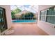 Back patio view of a swimming pool surrounded by a black safety fence and tropical plants at 12634 Ringwood Ave, Orlando, FL 32837