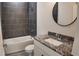 Modern bathroom featuring granite countertop vanity, sleek fixtures, and gray tiled shower over tub at 1313 Congo Dr, Kissimmee, FL 34759