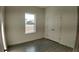 Bright bedroom with a closet, light-colored walls, a window, and gray wood-style tile flooring at 1313 Congo Dr, Kissimmee, FL 34759