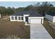 Modern one-story home featuring a two-car garage, black-framed windows, and a well-manicured lawn at 1313 Congo Dr, Kissimmee, FL 34759