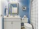 Bathroom with blue walls, a white vanity, and a white/blue shower curtain at 13258 Vennetta Way, Windermere, FL 34786