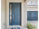 Attractive blue front door with sidelight window and a view of the paved driveway and garage at 13258 Vennetta Way, Windermere, FL 34786