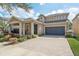 Beautifully landscaped home featuring a paved driveway, lush lawn, and a two-car garage at 13258 Vennetta Way, Windermere, FL 34786