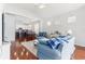 Spacious living room featuring hardwood floors, blue sofas, and an open view to the kitchen at 13258 Vennetta Way, Windermere, FL 34786