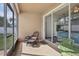 Enclosed patio featuring a wicker chair set and a green bistro set with a view of the interior at 13258 Vennetta Way, Windermere, FL 34786