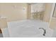 Bathroom with tile surround soaking tub, faucet, and a window at 1518 Orrington Payne Pl, Casselberry, FL 32707