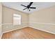 A bright bedroom features wood-look flooring and a ceiling fan, bathed in natural light from the window at 1518 Orrington Payne Pl, Casselberry, FL 32707