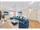 Bright and airy living room featuring a plush blue sectional, hardwood floors, and stylish decor creating a comfortable space at 1518 Orrington Payne Pl, Casselberry, FL 32707