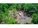 An aerial view of several vehicles in a clearing surrounded by a dense forest at 15345 Rockridge Rd, Polk City, FL 33868