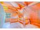 A unique attic bedroom features wooden paneling, hardwood floors, natural light from a window and railing at 15345 Rockridge Rd, Polk City, FL 33868