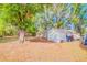 Large backyard with mature trees and storage sheds, ideal for outdoor activities and storage at 15345 Rockridge Rd, Polk City, FL 33868