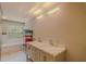 Bright bathroom showcasing a double sink vanity, marble floors, and a luxurious soaking tub at 15345 Rockridge Rd, Polk City, FL 33868
