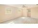 A bright, empty bedroom features light-colored walls, ceiling fan, and stylish light-colored flooring and windows at 15345 Rockridge Rd, Polk City, FL 33868