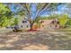 Exterior of a charming home with mature landscaping, a large shade tree, and an off-road vehicle at 15345 Rockridge Rd, Polk City, FL 33868
