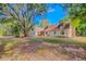 Charming two-story home with manicured front lawn and mature trees providing shade at 15345 Rockridge Rd, Polk City, FL 33868