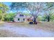 Exterior view showcases the house and expansive property with the garage and a yellow ATV at 15345 Rockridge Rd, Polk City, FL 33868