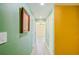 A well-lit hallway with light green and yellow walls leads to other rooms in the house at 15345 Rockridge Rd, Polk City, FL 33868