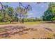 Lush green meadow with scattered trees under a bright blue sky with wispy clouds at 15345 Rockridge Rd, Polk City, FL 33868