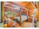 Unique main bedroom features a four poster bed, wood beams and paneling, hardwood floors, and chandelier at 15345 Rockridge Rd, Polk City, FL 33868