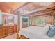Unique main bedroom features a four poster bed, wood beams and paneling, hardwood floors, and chandelier at 15345 Rockridge Rd, Polk City, FL 33868