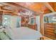 Unique main bedroom features a four poster bed, wood beams and paneling, hardwood floors, and chandelier at 15345 Rockridge Rd, Polk City, FL 33868