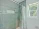 Modern shower featuring gray tile, a shower niche, glass accents and a shower window at 15345 Rockridge Rd, Polk City, FL 33868