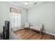 Cozy bedroom featuring wood floors, a ceiling fan, and comfortable seating near a bright window at 159 Ventana Dr, Kissimmee, FL 34759