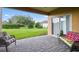 Covered patio with brick pavers, wicker furniture, and a view of the manicured lawn and landscaping at 159 Ventana Dr, Kissimmee, FL 34759