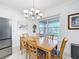 Dining room featuring a wooden table, chandelier, and natural light from a window at 1930 Molise Dr, Poinciana, FL 34759