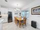 Bright dining room with a wooden table, chandelier, and adjacent kitchen area at 1930 Molise Dr, Poinciana, FL 34759