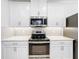 Modern kitchen featuring stainless steel appliances, white cabinets and countertops with a subway tile backsplash at 1930 Molise Dr, Poinciana, FL 34759