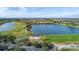 Aerial view of a lush Solivita golf course community with a scenic lake at 196 Knoll Wood Dr, Kissimmee, FL 34759