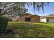 A beautiful backyard, featuring a screened lanai, a lush lawn, and shade trees for outdoor enjoyment at 196 Knoll Wood Dr, Kissimmee, FL 34759