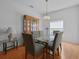 Elegant dining room featuring a glass-top table, upholstered chairs, a decorative chandelier, and a wooden china cabinet at 196 Knoll Wood Dr, Kissimmee, FL 34759