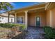 Inviting covered front porch with brick pavers, white columns, and manicured landscaping leading to a teal front door at 196 Knoll Wood Dr, Kissimmee, FL 34759