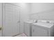 Laundry room featuring white washer and dryer with shelving, and white door at 196 Knoll Wood Dr, Kissimmee, FL 34759