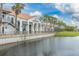 Picturesque water view of beautiful buildings by a serene waterfront, accented by palm trees and lush grass at 196 Knoll Wood Dr, Kissimmee, FL 34759