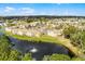 Aerial view of the residential complex and nearby pond and tree coverage at 2466 Sweetwater Club Cir # 4, Kissimmee, FL 34746