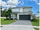 Two-story home boasts a brick paved driveway, dark garage door, manicured lawn, and well maintained landscaping at 2641 Calistoga Ave, Kissimmee, FL 34741