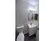 This bathroom has a white vanity, matching sink, toilet, and framed mirror at 3216 Fieldcrest Ter, Deltona, FL 32725