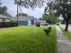 Suburban home featuring green grass, landscaping, mature trees, and a 'For Sale' sign at 3216 Fieldcrest Ter, Deltona, FL 32725