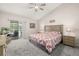 The primary bedroom features a ceiling fan, sliding glass door, and neutral color palette at 336 California Blvd, Davenport, FL 33897