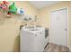 Efficient laundry room with washer, dryer, shelving, and ample storage space at 336 California Blvd, Davenport, FL 33897