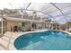 Inviting screened-in pool area with an outdoor dining set and a mounted tv for entertainment at 336 California Blvd, Davenport, FL 33897