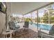 Inviting screened-in pool area with comfortable chairs, a decorative rug, and a mounted tv for outdoor entertainment at 336 California Blvd, Davenport, FL 33897