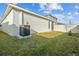 The backyard of this home features a grassy lawn and an air conditioning unit on a concrete slab at 3930 Palazzo Pl, Winter Haven, FL 33884